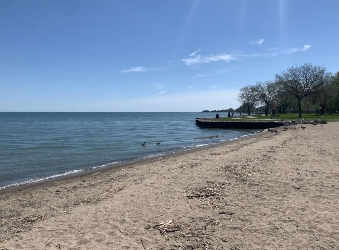 A beach with a pier extending into the waters.